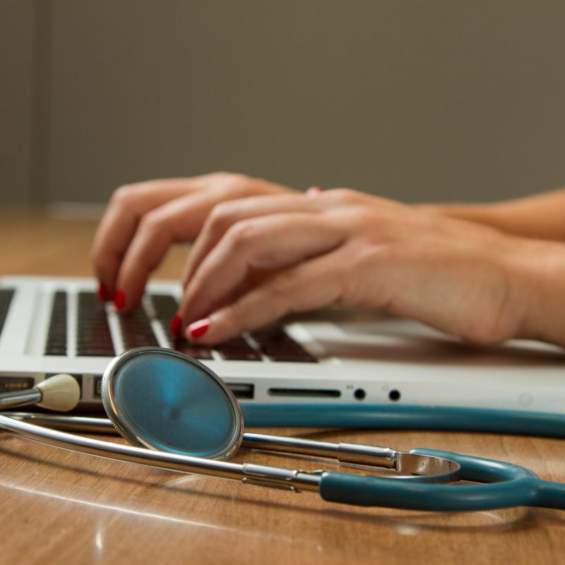 Nurse reviewing her nursing resume for a job search on a laptop